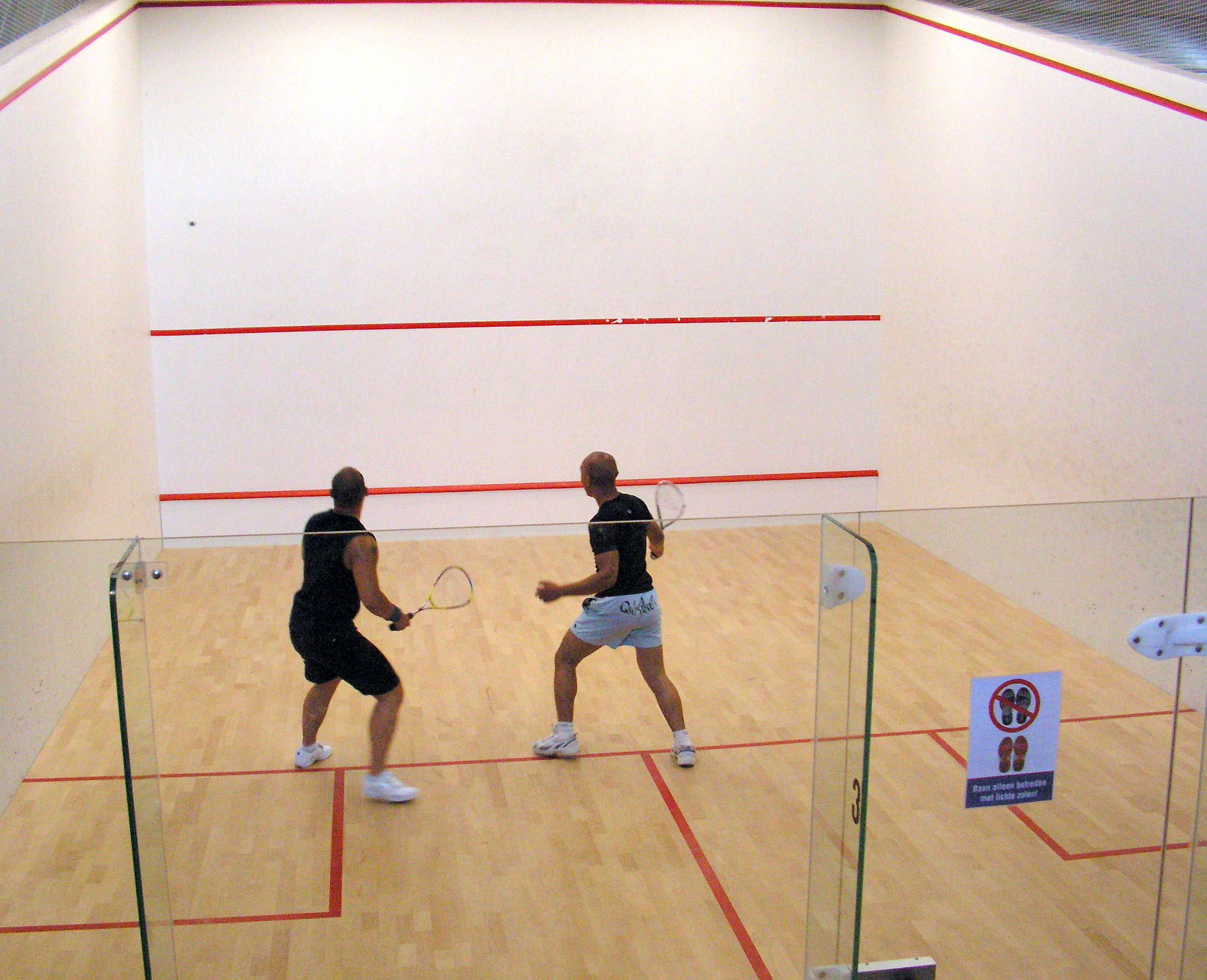 Squash match viewed through the glass back wall